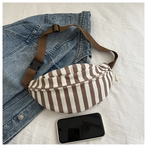 Detailed view of striped corduroy belt bag with adjustable strap and casual accessories
