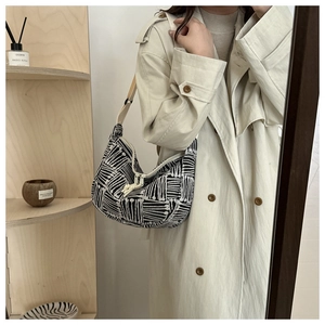 Detail of hobo tote bag with black and white stripes, adjustable strap, and hobo shape