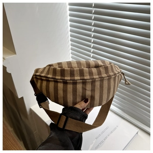 Detail of brown corduroy belt bag with stripe texture and adjustable buckle strap
