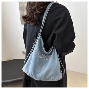 Détail du cabas en denim bleu clair avec broderie blanche less Monday more Sunday