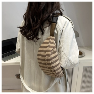 Detailed view of striped corduroy waist bag with adjustable strap worn by a model