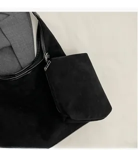 Détail d'un grand sac bandoulière noir en suédine avec une petite pochette zippée assortie