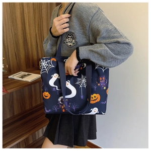 Detail of Halloween ghost and pumpkin prints on durable nylon tote bag with black strap