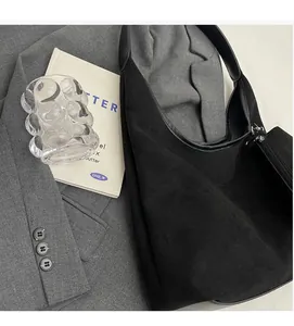 Détail du grand sac cabas noir en daim avec bandoulière large et pochette assortie