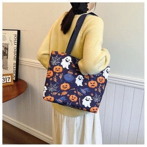 Halloween ghost tote bag with pumpkin print on dark blue canvas held by model