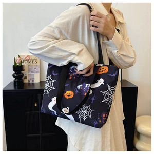 Detail of Halloween tote bag showing ghost and pumpkin prints on large black canvas
