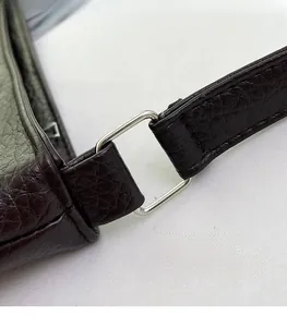 Detail of silver rectangular metal ring connecting the crocodile pattern leather shoulder strap