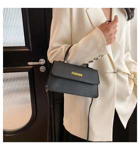 Detail der schwarzen Handtasche mit Litschi-Muster Leder und FASHION Logo Schriftzug
