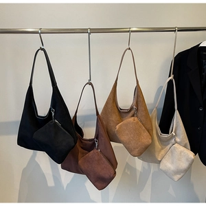Détail de grands sacs hobo en daim en noir, marron, camel et beige avec petites pochettes