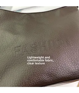 Detail view of the soft lychee grain brown leather bag with embossed FASHION lettering