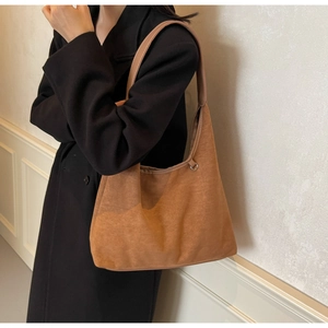 Détail du sac cabas en daim marron avec large bandoulière et anneaux métalliques