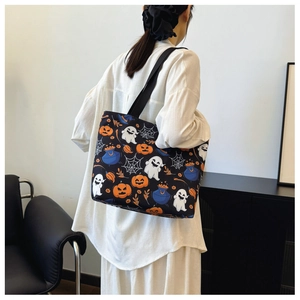 Detail view of the Halloween tote bag with pumpkin and ghost prints on black canvas