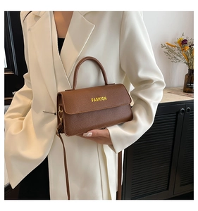 Detailansicht des braunen Leders mit Litschi-Muster und FASHION-Schriftzug auf der Tasche