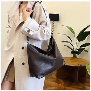 Detail of soft leather hobo bag featuring fashion letter embossing in dark coffee brown