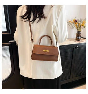 Brown lychee texture crossbody bag styled with a white blazer and black skirt