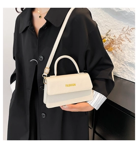 Close-up of a cream white lychee texture handbag with Fashion lettering in a street style view