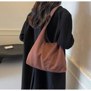 Sac hobo en daim marron avec texture vintage douce et grande capacité porté à l'épaule