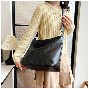 Lifestyle shot of large black lychee textured tote bag with FASHION embossed detail