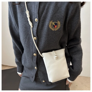 Détail d'un sac à bandoulière blanc en cuir pour téléphone avec bouton perle sur modèle