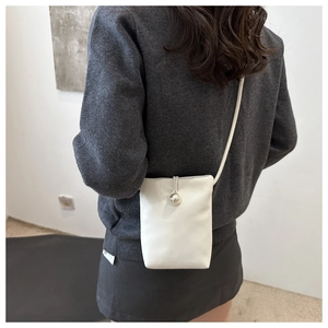 Vue détaillée du mini sac bandoulière blanc en cuir avec boucle perle sur un mannequin