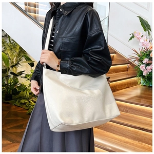 Detailed macro view of white pebble leather tote bag with embossed fashion lettering