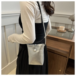 Vue détaillée du mini sac bandoulière argenté avec boucle perle et finition satinée