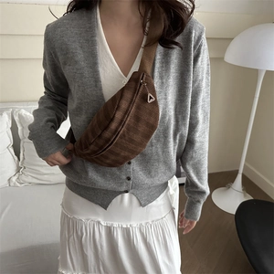 Brown corduroy crossbody chest bag with wide strap shown on model in warm studio setting