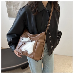 Dettaglio borsa shopper marrone in PU con patch cane in peluche e fiocco a quadretti