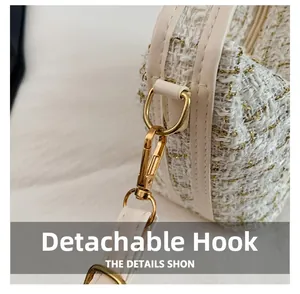 Detail of gold detachable metal hook and D-ring on white tweed crossbody bag strap