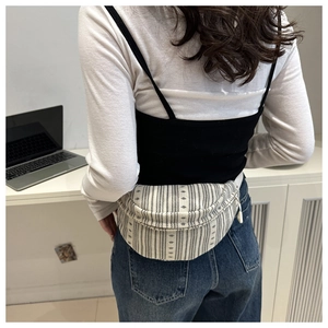 Detailed view of bohemian canvas saddle bag with geometric stripes on a casual model