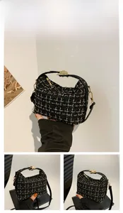 Detail of black tweed crossbody bag with golden grid pattern and metallic hardware