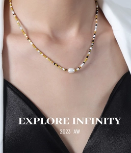 Detail of beaded necklace with colorful glass beads and a single white pearl pendant