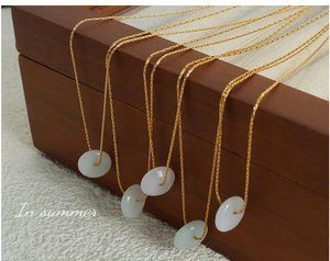 Vue détaillée du pendentif en jade Hetian avec chaîne en acier titane plaqué or 18 carats
