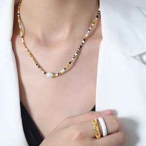 Handmade beaded necklace with natural freshwater pearl and geometric beads on a model