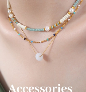 Gros plan sur un collier triple rang plaqué or avec pendentif en jade et perles élégantes