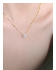 Gros plan sur un collier en titane plaqué or avec un pendentif élégant en jade Hetian
