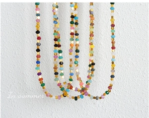 Detail of colorful faceted jasper beads and gold metal spacers on a vibrant necklace