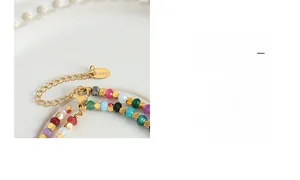 Detail of colorful faceted stone beads with gold spacers and stainless steel lobster clasp
