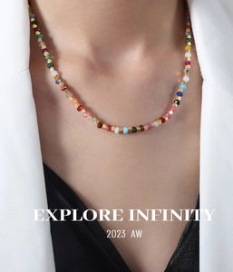 Detail view of colorful faceted stone bead necklace with gold spacers on a model
