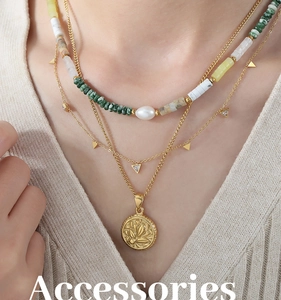 Détail du collier multi-rangs avec perles vertes et un pendentif à relief doré floral