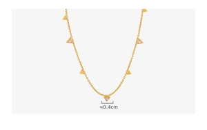 Détail macro de pendentifs triangles de 0,4 cm avec zircons sur collier doré minimaliste