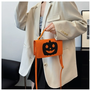 Detail of orange pumpkin crossbody bag with black Jack-o'-lantern face embroidery