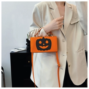 Model wearing a stylish orange pumpkin-shaped crossbody bag with a black jack-o'-lantern face