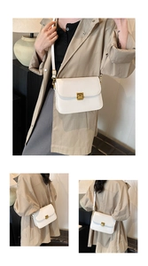 Detailed view of white crossbody bag with gold rectangular buckle and slim shoulder strap