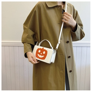 White Halloween crossbody bag featuring orange pumpkin smile face and adjustable strap