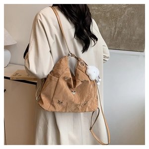 Vue détaillée du sac plissé camel avec papillons en métal et pendentif nuage en peluche