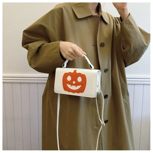 Detail view of the orange pumpkin patch on a white PU leather crossbody bag for Halloween