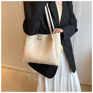 Detail of the cream PU leather tote bag with FASHION embossed logo and shoulder straps
