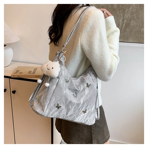Silver metallic hobo bag featuring 3D butterfly accents and a plush cloud charm detail