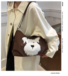 Détail d'un sac à bandoulière marron avec applique de chiot en peluche et anses fines